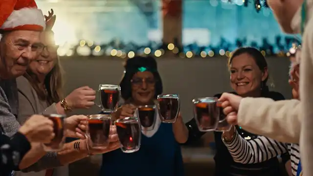 People toasting with glass mugs of mulled wine