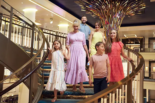 A smartly dressed family descending stairs on a P&O Cruises ship